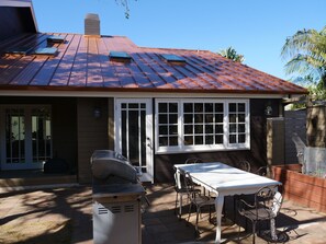 BBQ and one of 2 outdoor tables. Door to kitchen. Many skylights.