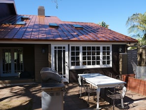 BBQ and one of 2 outdoor tables. Door to kitchen. Neither yard is fully enclosed