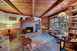 Den with fireplace, HDTV and cable, stereo, CD player, books, and grand window to view the thriving bird and animal life.