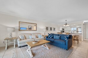 Living area with two sofas is open to the dining area and kitchen.