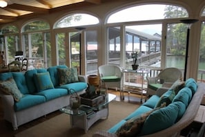 Seating on sunporch with view of boat house and lake