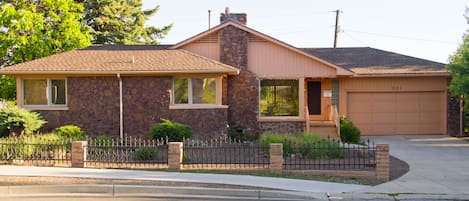 Rock house has a one car garage with a long concrete driveway