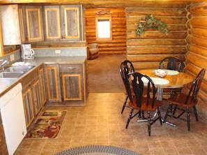 The lovely eat-in kitchen has dining for 4 & custom cabinets made by the owner.