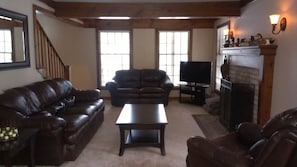 Cozy living room with all leather furniture, TV with cable and blu ray player.