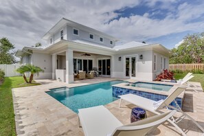 Backyard pool area, covered loggia with seating and outdoor kitchen