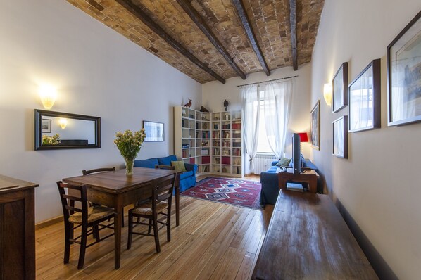 Dining table and living room with sofas.Original high vaulted beamed ceiling