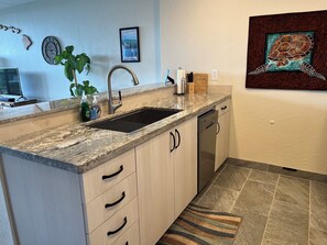 Kitchen continued, with bar counter and bar stools.