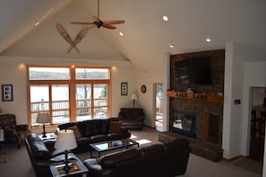 View of great room facing lake with 65-inch TV & fireplace
