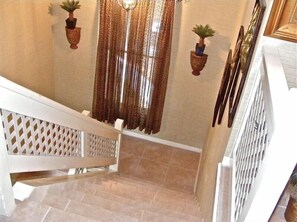 Tiled Stairs Leading To Upstairs Villa With Golf, Lagoon, and Wooded Views.