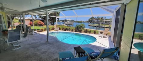 Outside screened lanai and pool overlooking dock and Dona Bay.