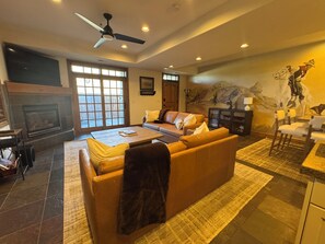 Living room has 2 large sofas, TV and fireplace.