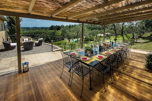 Outdoor dining area (wooden pergola) with a full set of table + chairs, seating up to 16 guests 