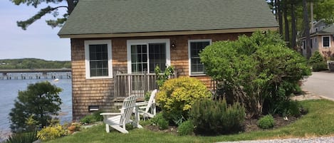 Exterior of cottage and side yard with Adirondack chairs