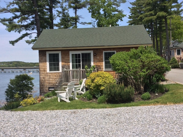 Exterior of cottage and side yard with Adirondack chairs