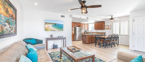 Main living and dining area with sliding glass doors to front ocean view balcony. Ceiling fans throughout.