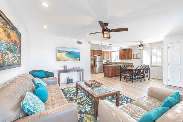 Main living and dining area with sliding glass doors to front ocean view balcony. Ceiling fans throughout.