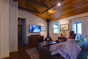 Living room has a large screen smart TV, extra center speaker, Dish for movies.