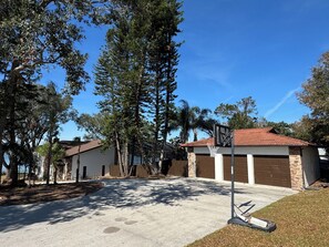 View from the road of garage, house, and lake.