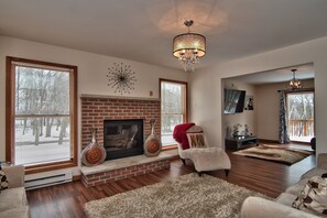 Relaxing room, red brick gas fireplace, couches, lounge chair, lots of light