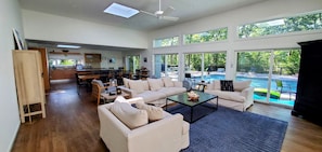 Newly renovated, open concept living and dining room with views of the pool. 