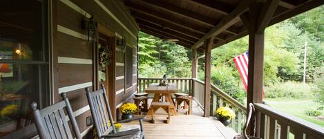 Front porch with rocking chairs and picnic table.