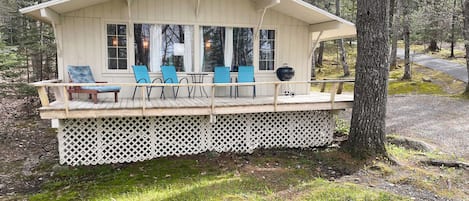 Large windows and deck offer a peaceful view of the whispering pines.
