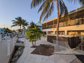 Spacious back yard with pavers, hot tub, grille and hammock.