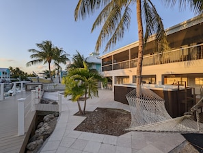 Spacious back yard with pavers, hot tub, grille and hammock.