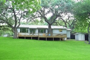 Majestic oaks shade the large deck overlooking the yard and river.