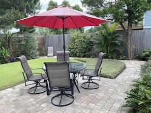 Beautiful paved back yard, with outdoor dining.