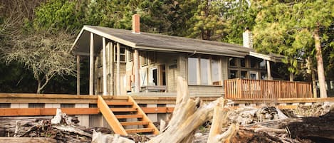 View of house from beach with seawall and stairs 