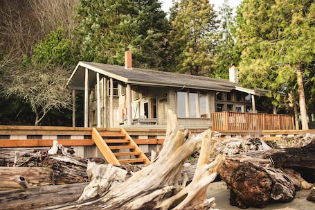 View of house from beach with seawall and stairs