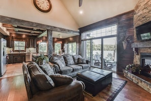 Living area with stone fireplace, huge fan, custom furniture and tall ceilings!