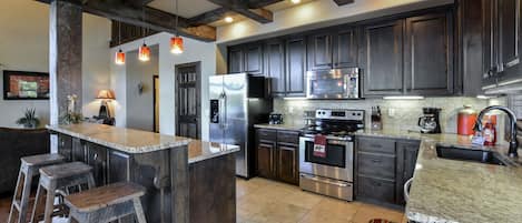 Gourmet Kitchen with granite countertops, stainless appliances and wood beams!