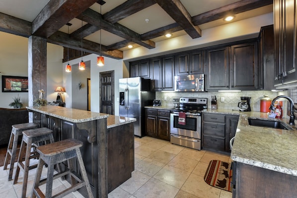 Gourmet Kitchen with granite countertops, stainless appliances and wood beams!