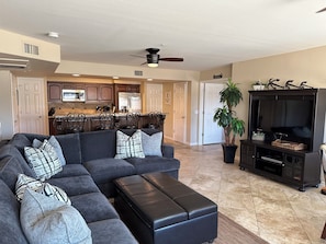 As you walk in, see open living area, tv, bar, and kitchen.