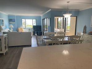 view from kitchen of dining area, family room, and lanai overlooking beach