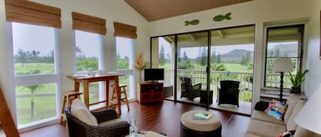 Living room, dining table and wrap-around view of mountains and golf course