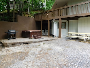 Expanded deck up with many rocking chairs and sitting area below at hot tub