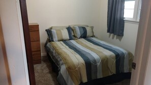Bedroom one includes a dresser and a full-size bed.