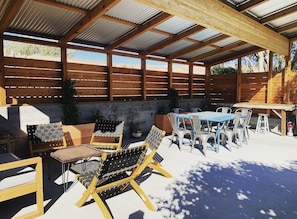 Private covered patio with seating and gas BBQ