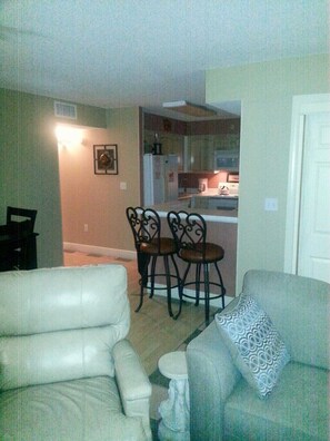 Den adjoins fully outfitted kitchen with bar.