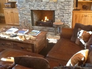 WARM ROCK HEARTH AND FIREPLACE CENTERED IN THE GREAT ROOM