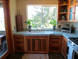 Well-stocked kitchen w/new appliances. Custom cabinets & just off the porch.
