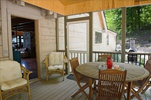 Screened in porch with access to the outdoor fireplace on patio and the fire pit