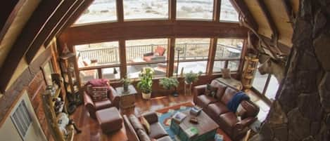 View from loft to living room with deck outside.