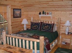 Upper level bedroom w/television leads out to covered balcony overlooking creek