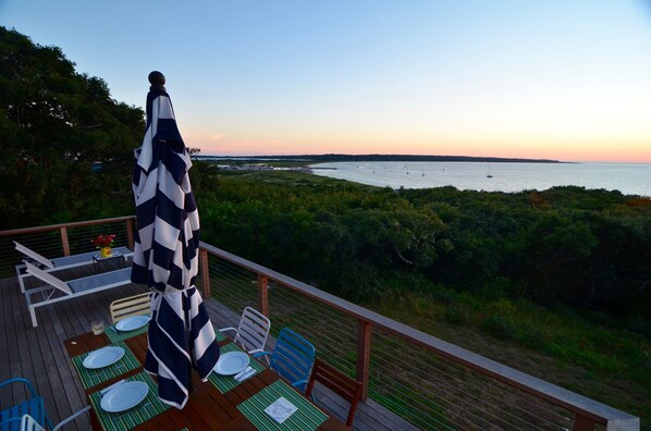 Deck with sunset water views of Menemsha Harbor & Gay Head Lighthouse.