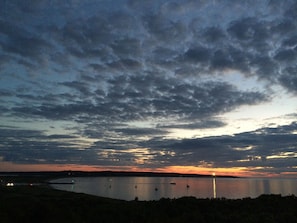 Sunset from deck, Aug'14. Green Menemsha Jetty light & Gay Head Lighthouse.