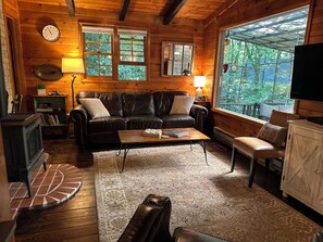Open Living Room with leather sofa & recliner, gas log stove, and flat-screen TV